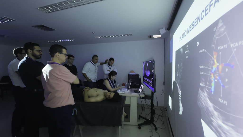 Instrutor apontando para ecocardiografia com Doppler colorido projetada durante a imersão